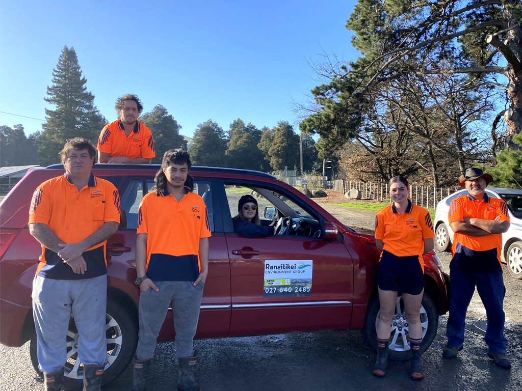 Group of people standing around a car